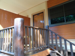 A wooden staircase with a metal handrail leading to a door with the number 7. - Khunnam Rimtarn Resort (Mae Sai)