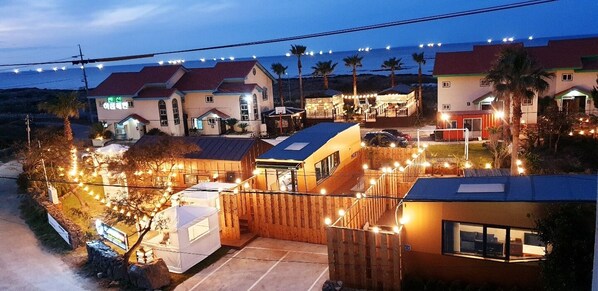 A residential area with houses, a basketball court, and a small building with a sign. - Morning Beach Pension (Jeju City)