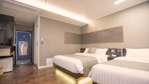 A hotel room with two beds, a bedside table with a phone, a wall-mounted TV, and a bathroom visible through an open door. - Hotel Major 2 (Jeju City)