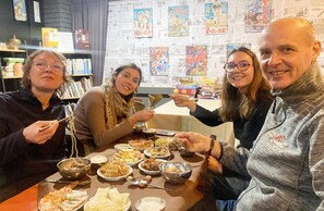 Un grupo de personas cenando en un restaurante con varios platos sobre la mesa.