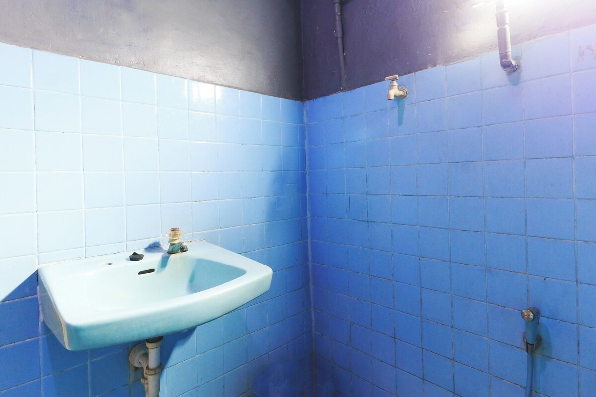 Un baño con azulejos azules, un lavabo y una ducha.