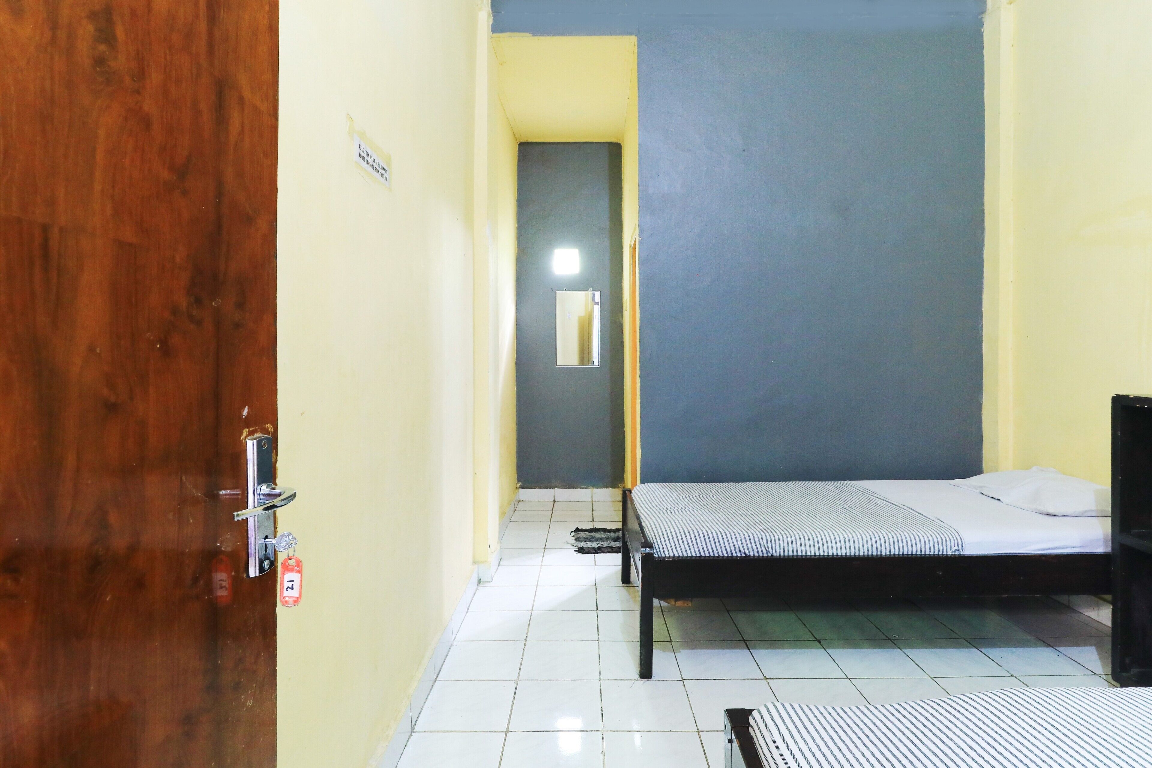 A room with a bed, a door, and a small window.