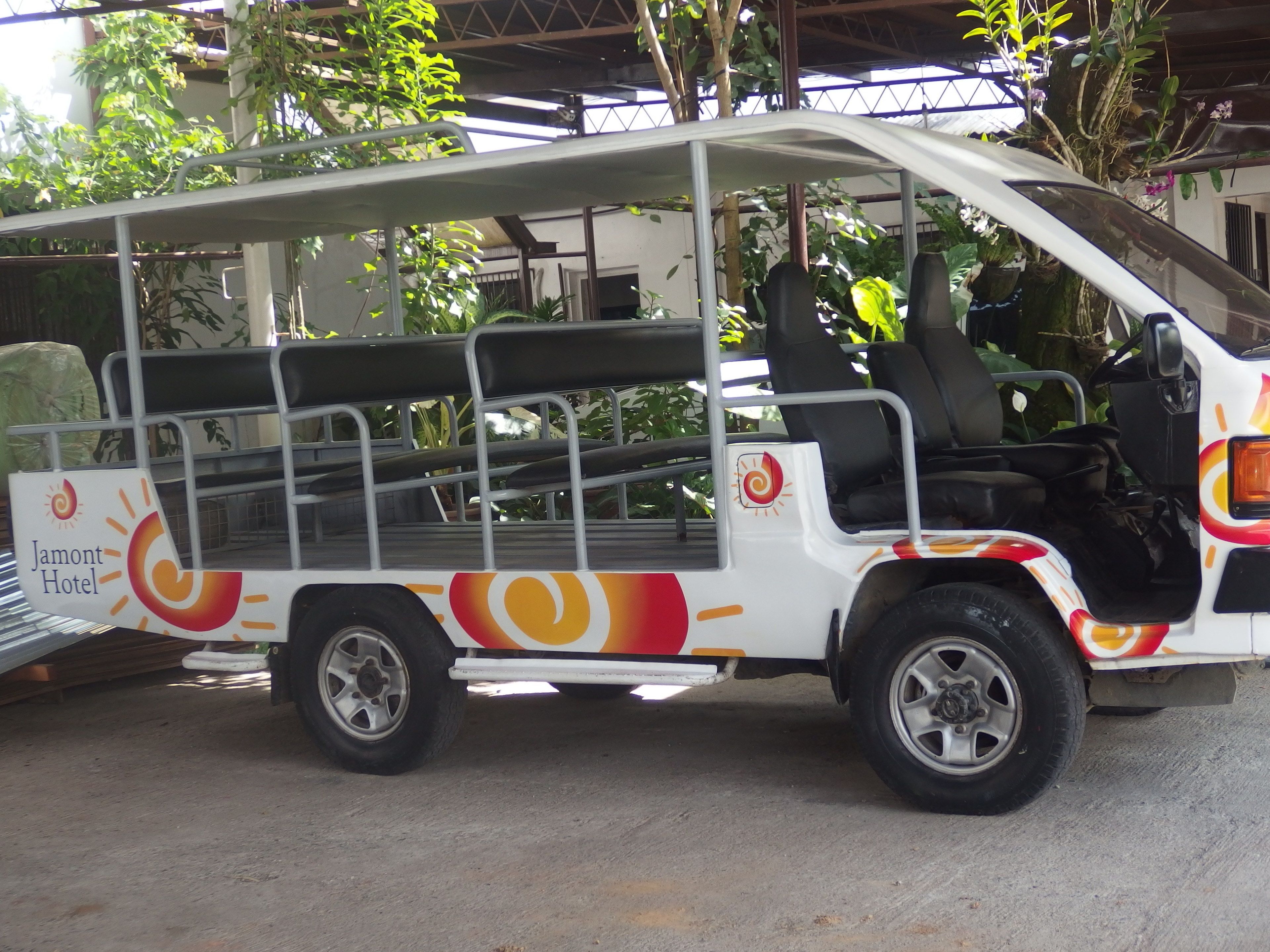 A white vehicle with a sun and swirl design, labeled "Jamont Hotel" on the side.