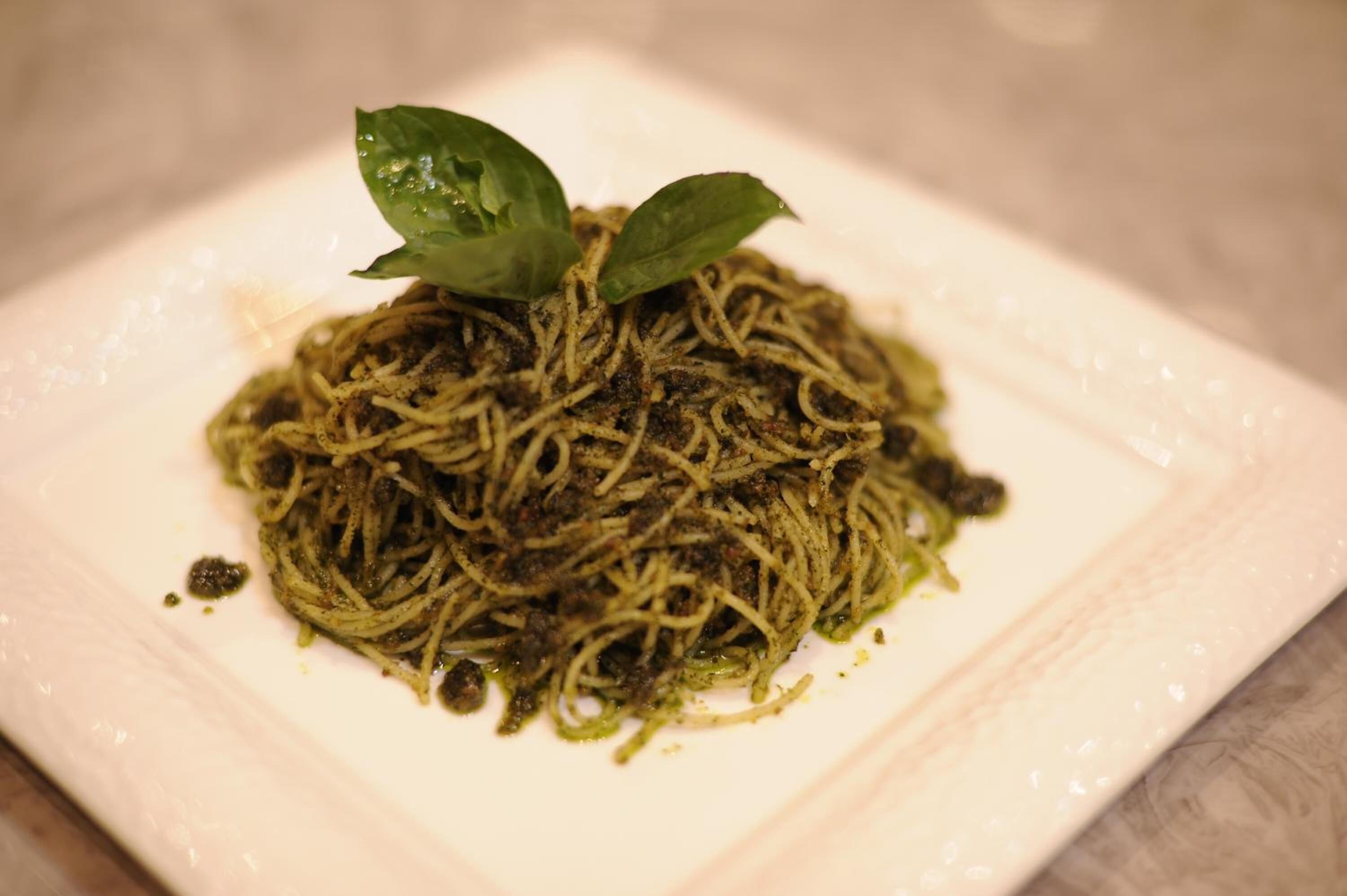 Un plato de espagueti con adorno de albahaca.