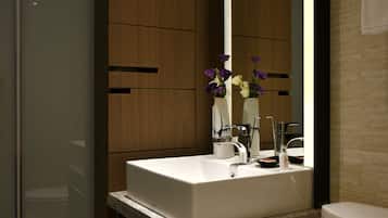 A modern bathroom with a built-in sink, a mirror, and a toilet.