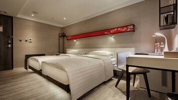 A modern hotel room with a large bed, a desk, and a chair.