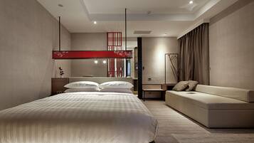 A modern bedroom with a large bed, a sofa, and a red decorative panel.