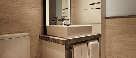 Un bagno moderno con il water, un lavandino e uno specchio.