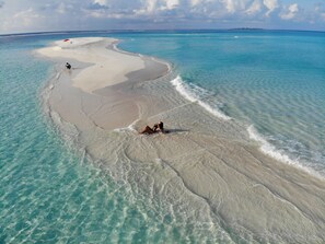 An aerial view of a beach with clear turquoise waters and a sandy shore. - Lagoon View Maldives (Bodufolhudhoo)