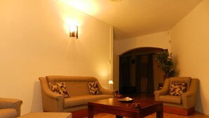 Un salon comprenant un canapé, une table basse et une lampe.