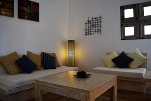 A modern living room with a sofa, a coffee table, and a wall-mounted light fixture.