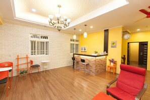 A hotel lobby with a brick wall, wooden flooring, a reception desk, and a red chair. - N. Castle Hotel (Yilan)