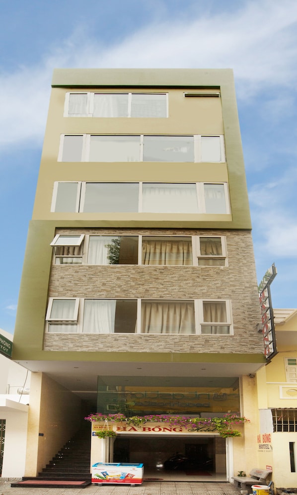 A multi-story hotel with a flat facade, multiple windows, and a sign indicating it is the Ha Bong Hotel. - Phuong Tung Hotel (Da Nang)