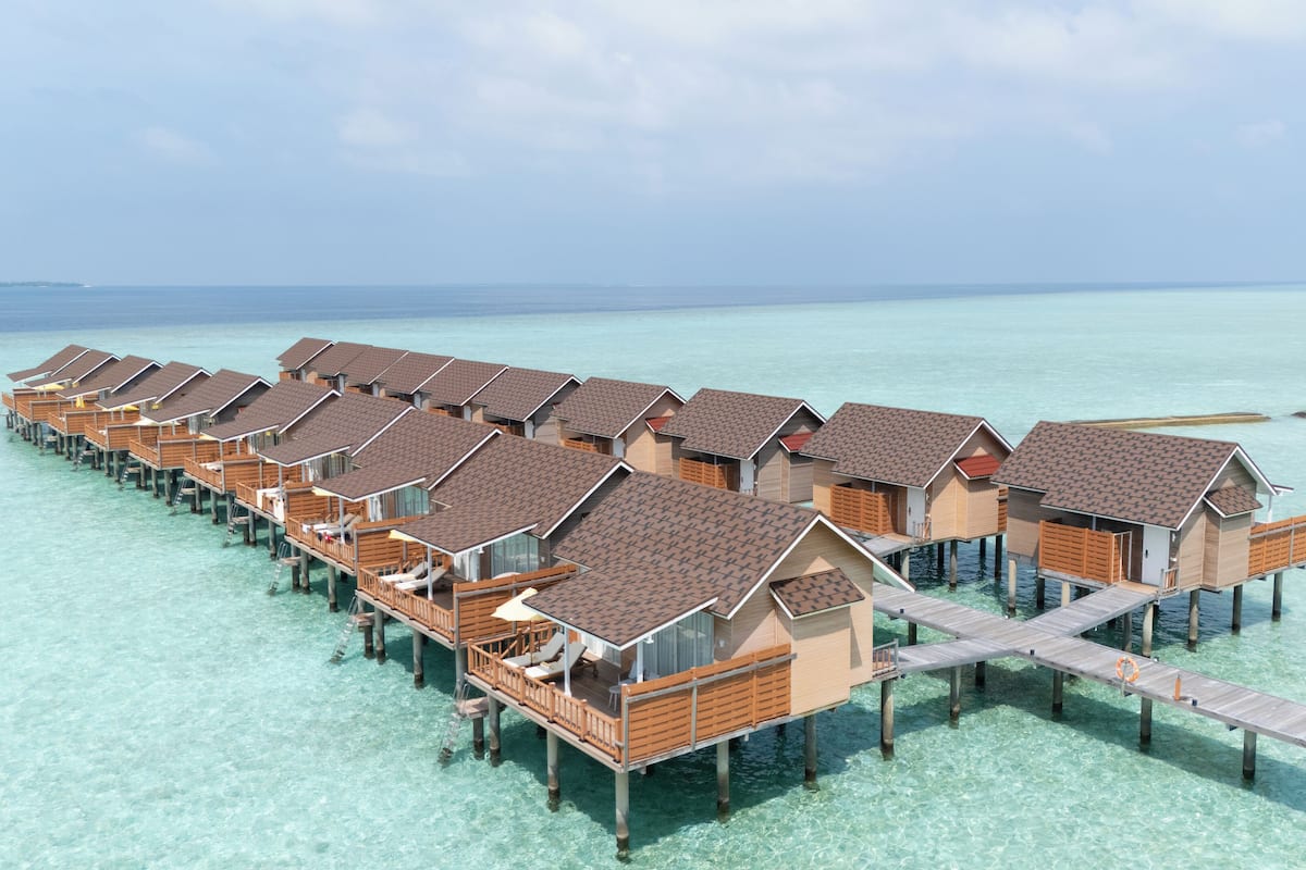 Eine Reihe von überwasserbungalows, verbunden durch eine Holzterrasse.