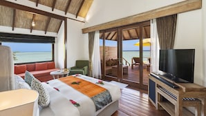 Una habitación amplia con una cama grande, televisión y balcón con vista al mar.