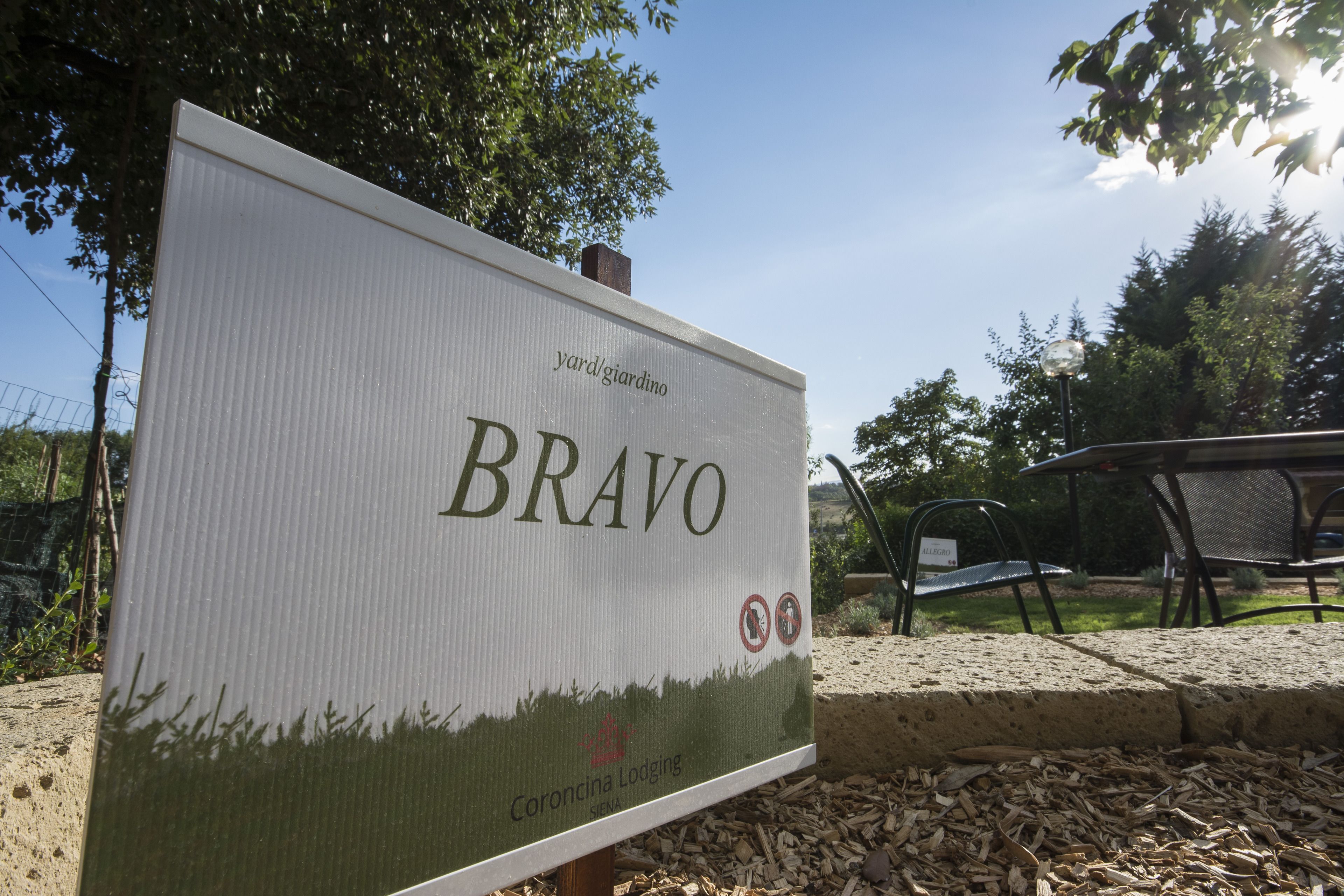 Señal de 'Bravo' en Coroncina Lodging, con zona verde y mobiliario exterior.