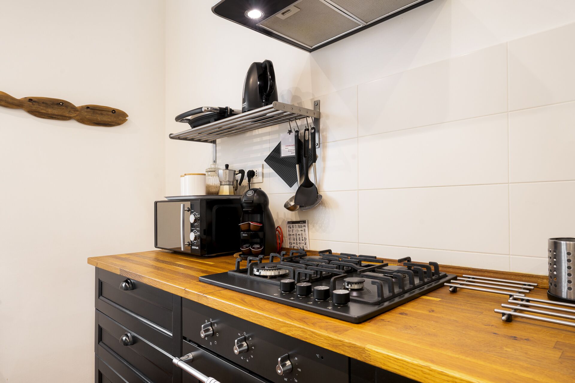 Una cocina con estufa, tostadora y cafetera.