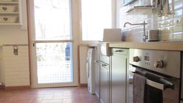 A kitchen with a stove, oven, and a washing machine.