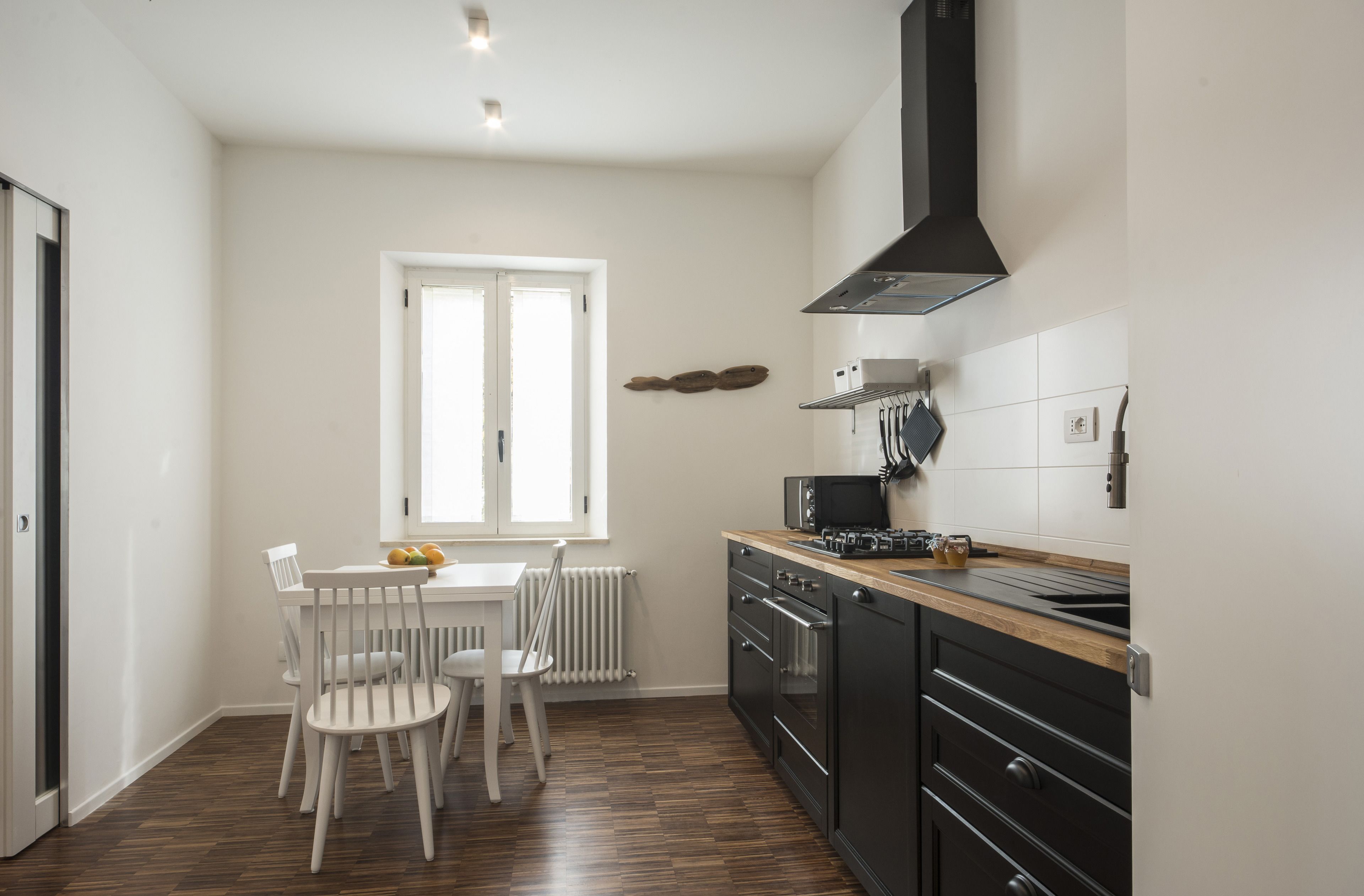 Una cocina con una mesa de comedor, sillas, un microondas y una estufa.
