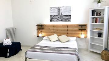 Une chambre à coucher moderne, avec un lit, une table de chevet, une bibliothèque et un radiateur.