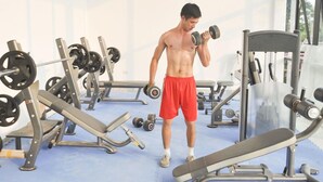 A gym with various exercise equipment including dumbbells, benches, and weight machines. - Phoenix Hotel (Hac Thanh)
