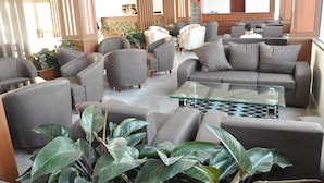 A modern lobby with sofas, armchairs, and a glass coffee table. - Phoenix Hotel (Hac Thanh)