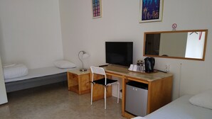 A hotel room with a bed, a desk with a computer, a chair, a small refrigerator, and a television. - Milano Garden - City Bungalow Hotell, i gränssnittet till Kullabygdens pärlor (Astorp)