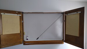A room with a wooden-framed window, a white wall, and a visible electrical outlet. - Milano Garden - City Bungalow Hotell, i gränssnittet till Kullabygdens pärlor (Astorp)