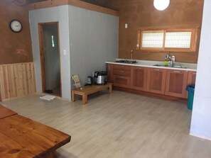 A compact kitchen with wooden cabinets, a built-in stove, and a small window.