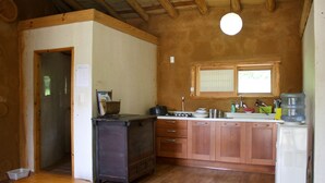 Une cuisine de taille réduite, avec des meubles de rangement en bois, une cuisinière et un réfrigérateur.