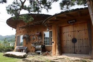 Un bâtiment rustique en bois, doté d’une grande porte en bois, d’une fenêtre et d’une enseigne au-dessus de la porte.