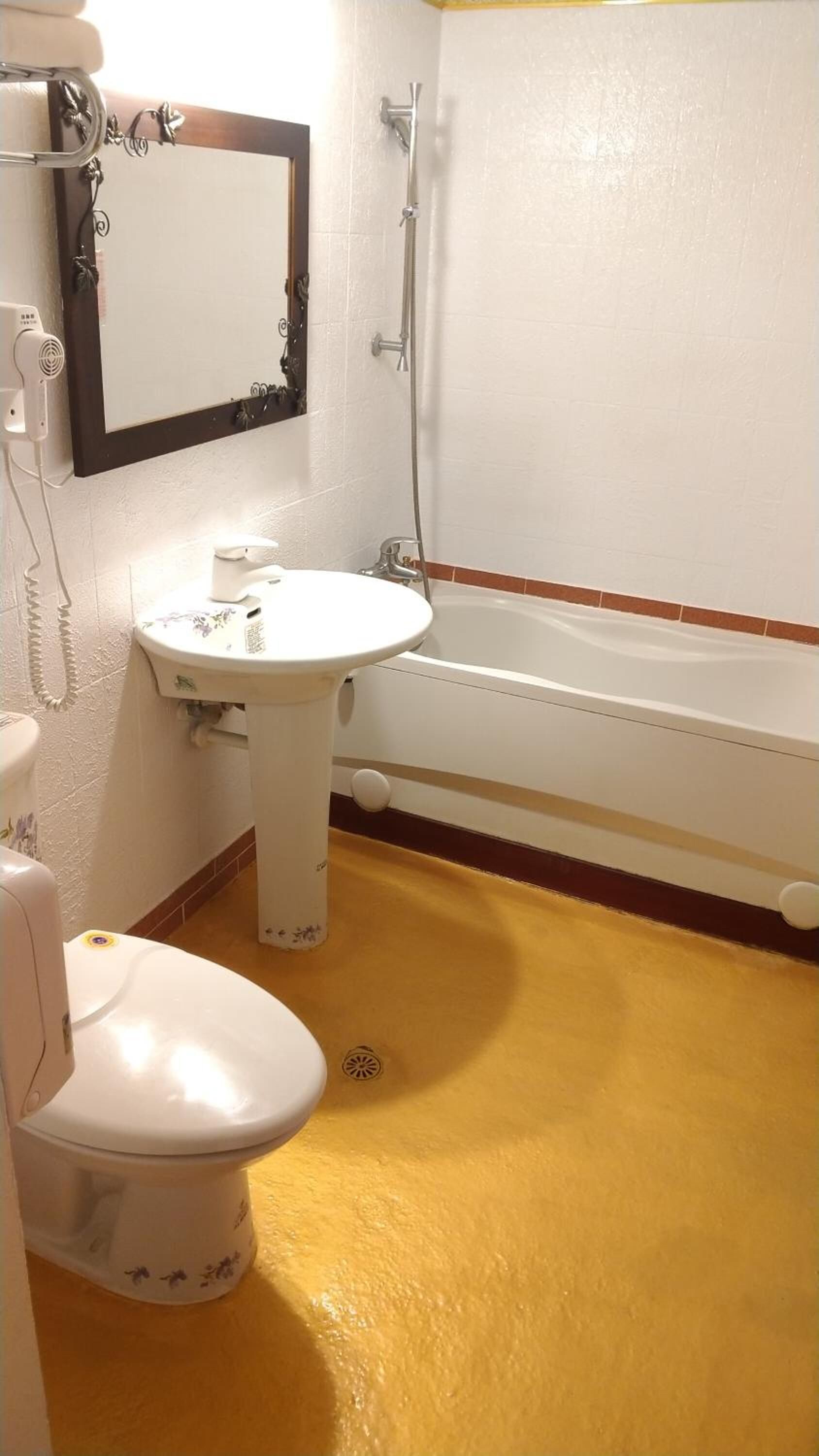 A bathroom with a toilet, sink, and bathtub.