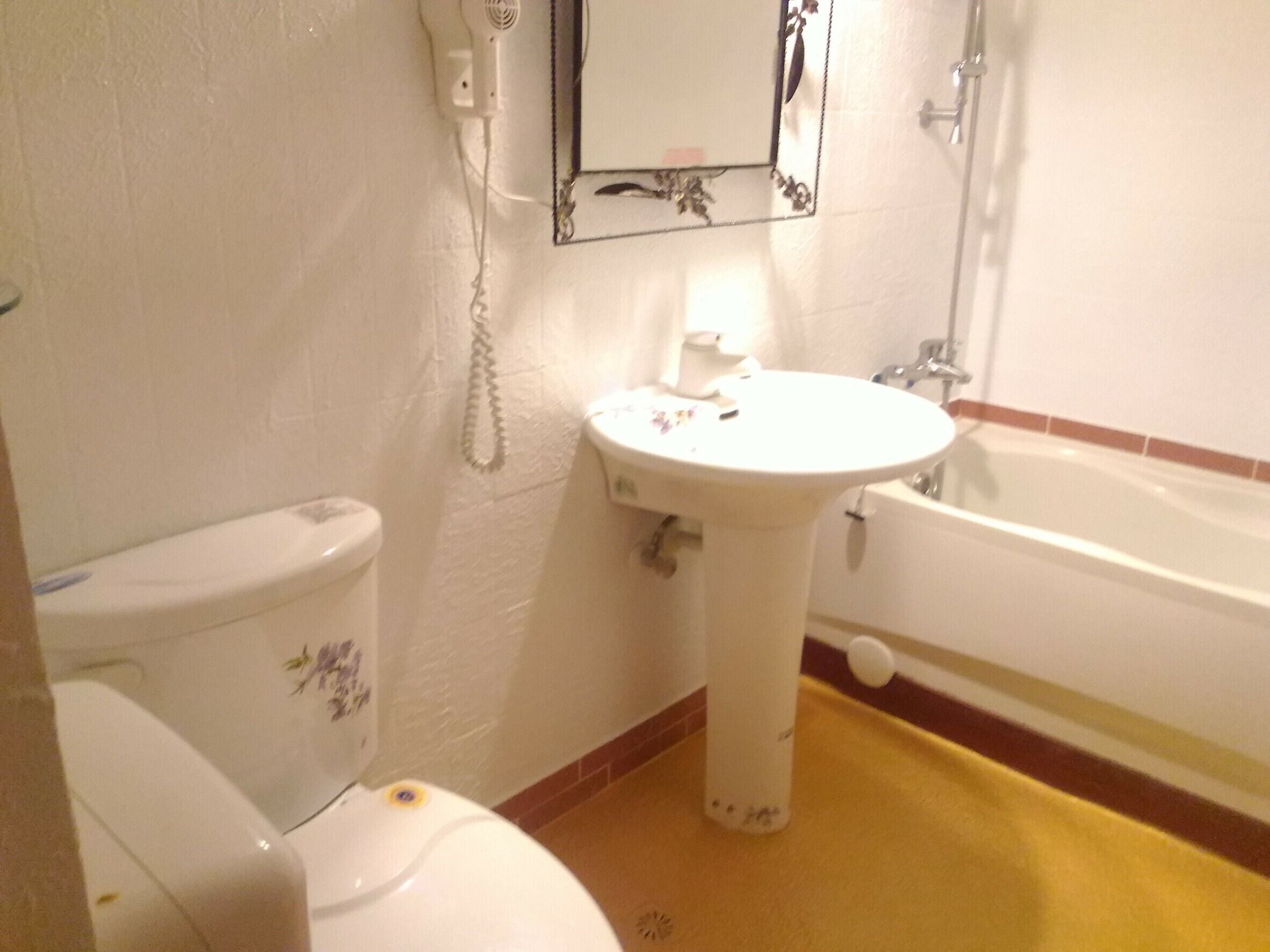 A bathroom with a toilet, sink, and bathtub.