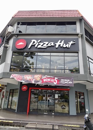 Un restaurante Pizza Hut con un gran anuncio que promociona una oferta especial.