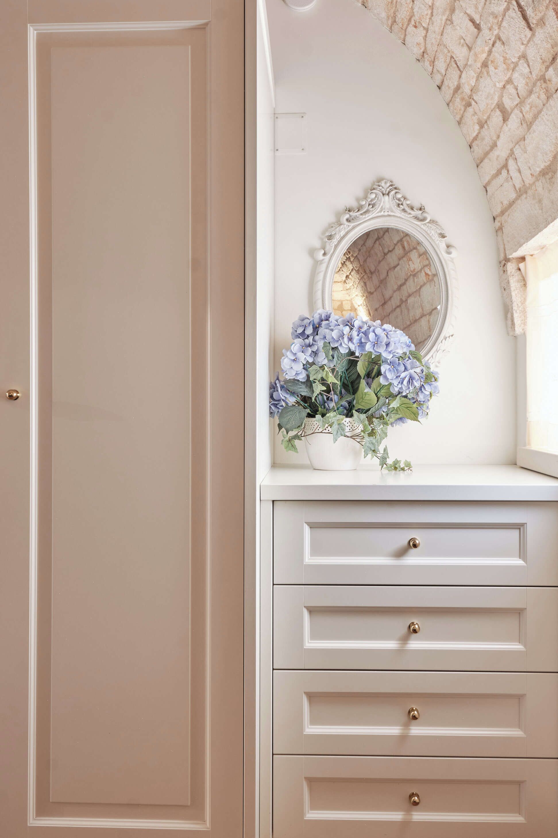 A white dresser with three drawers and a mirror above it.