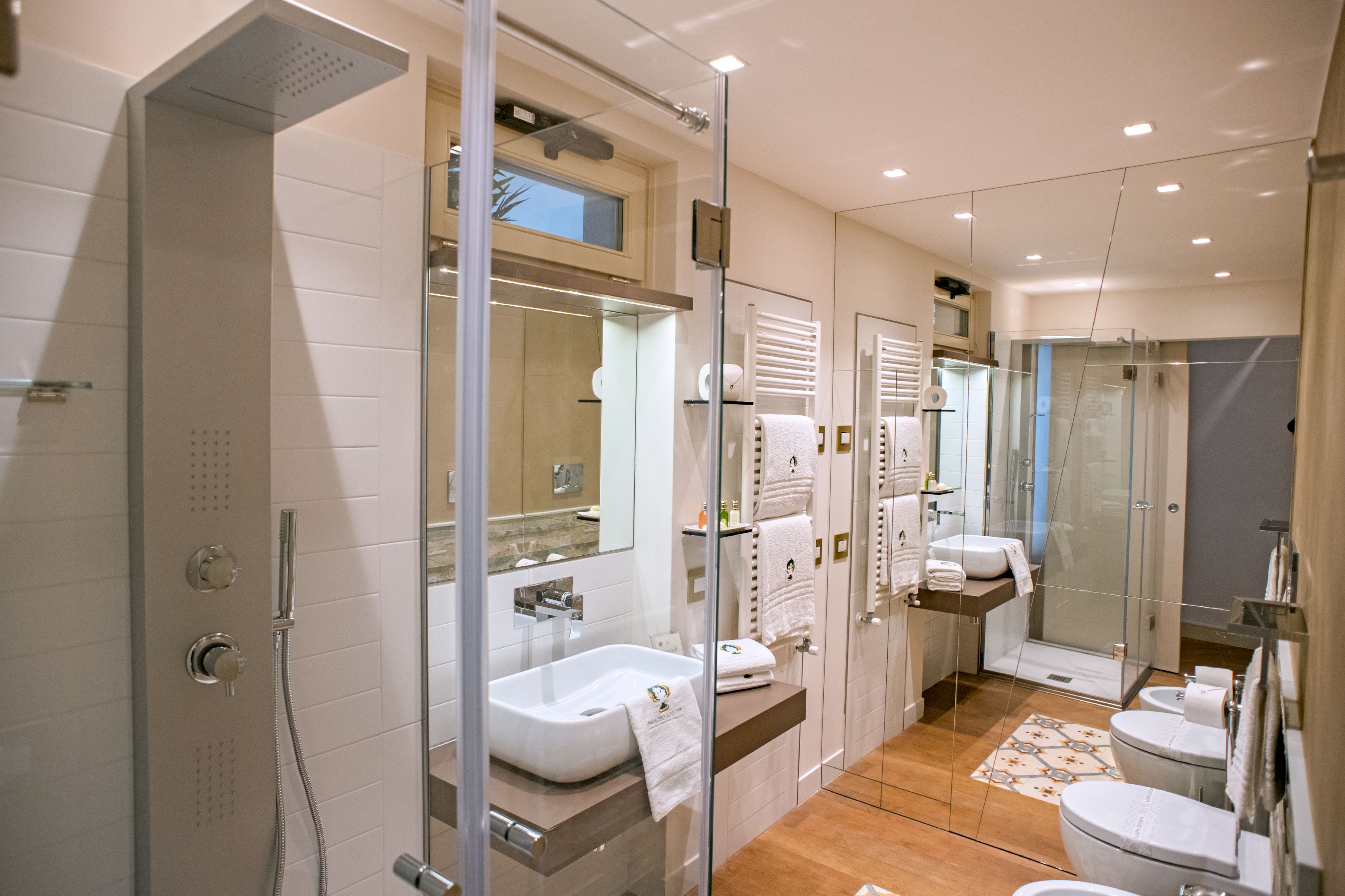 A modern bathroom with a glass-enclosed shower, a large sink, and a toilet.