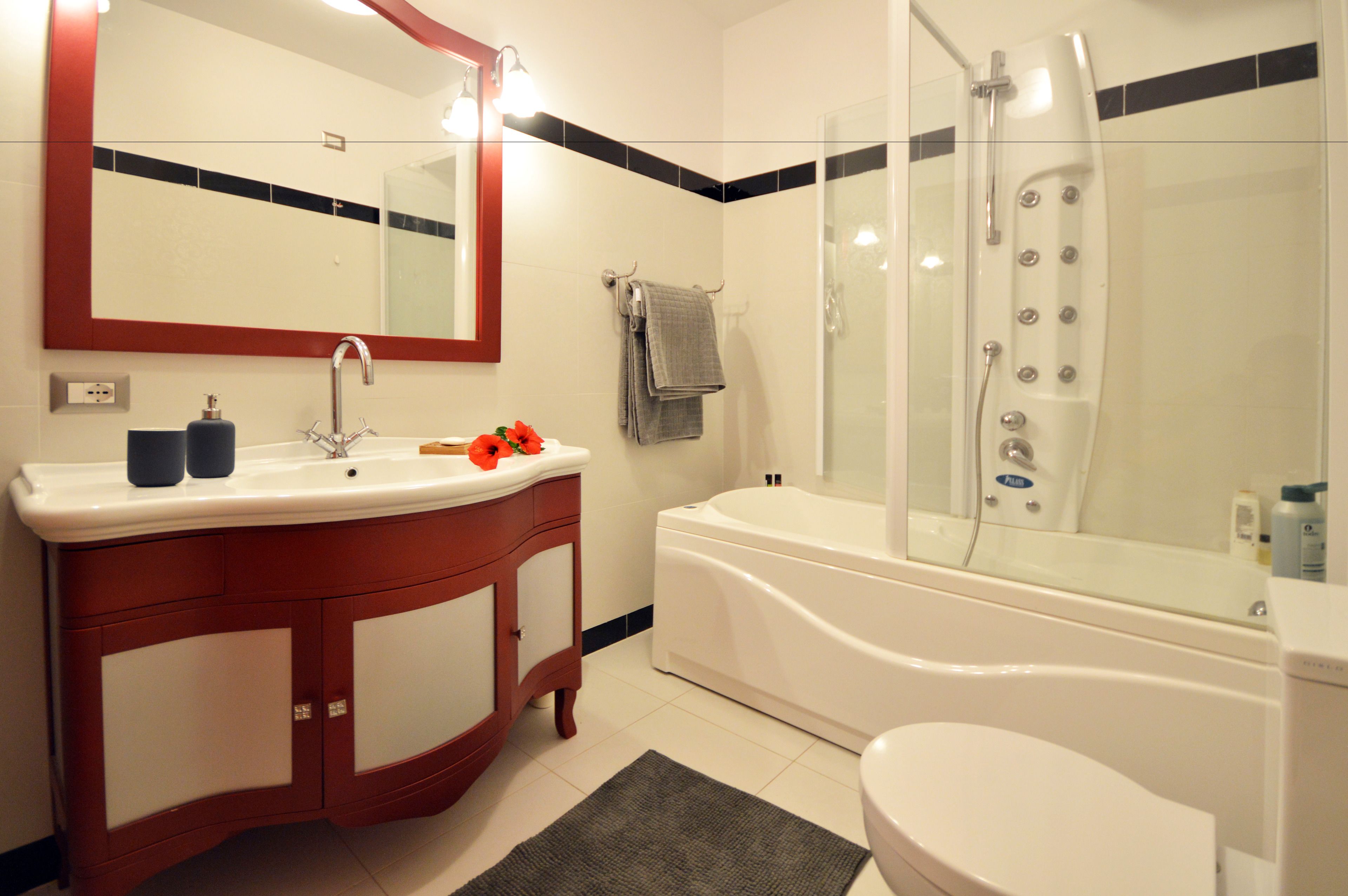 Een badkamer met een wit wastafelmeubel en een bad.