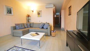 Una sala de estar con sofá, mesa de centro, televisor y chimenea.