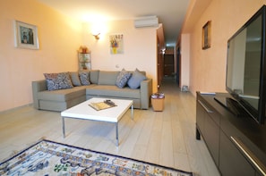 Superior suite, uitzicht op zee | Woonkamer | Lcd-televisie