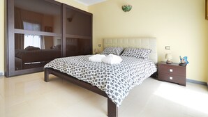Un dormitorio con cama, mesita de noche, lámpara de pared y un adorno.