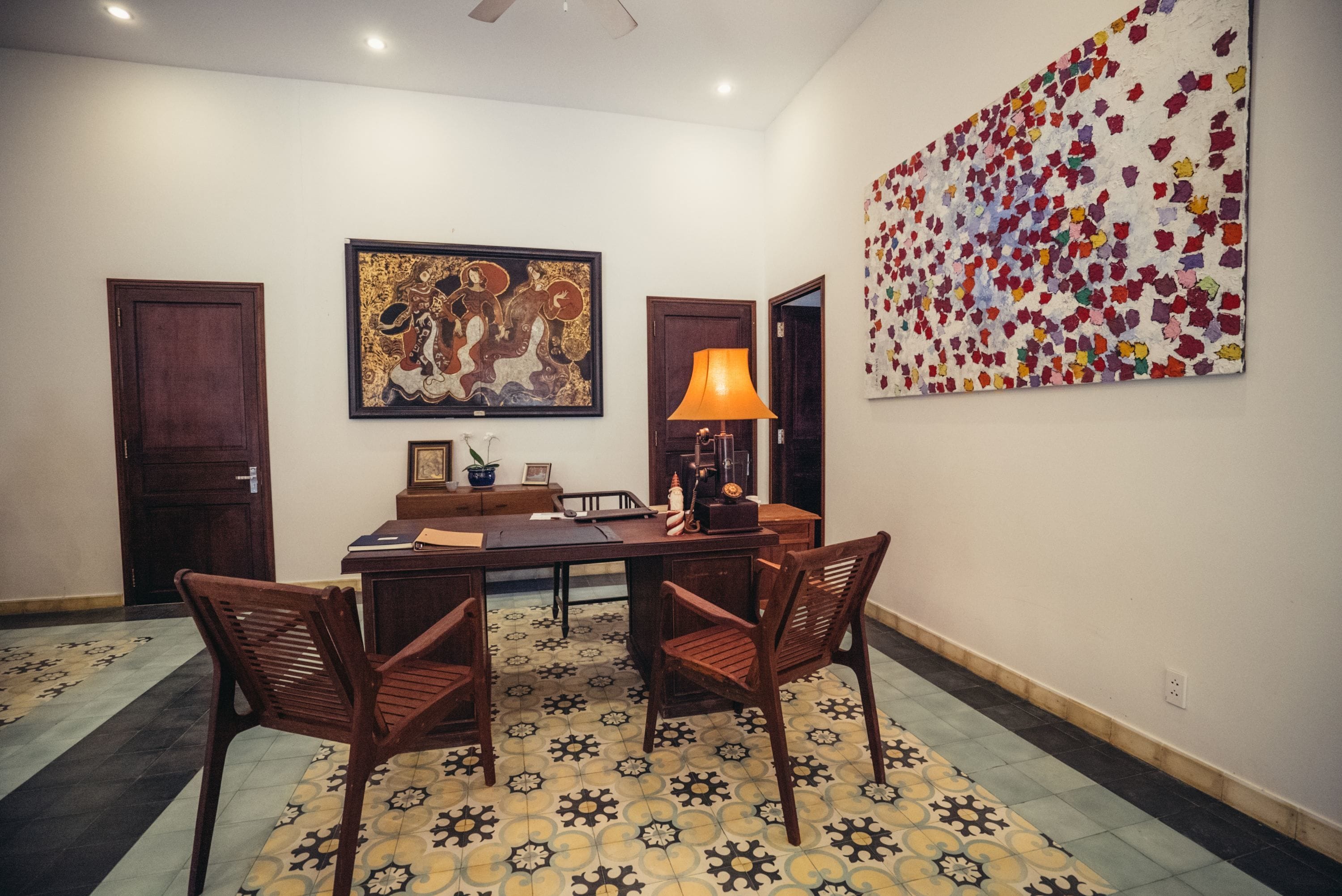Un comedor con una mesa, sillas y obras de arte en las paredes.