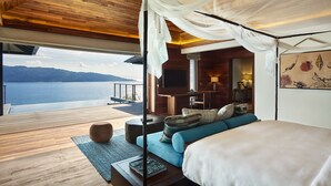 Un dormitorio con una cama grande, un televisor y vistas a un lago.