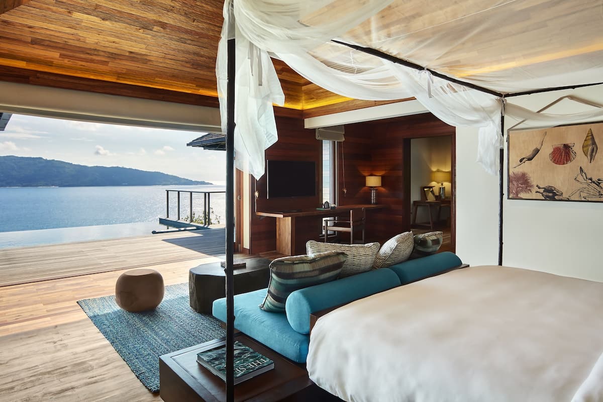 Un dormitorio con una cama grande, un televisor y vistas a un lago.