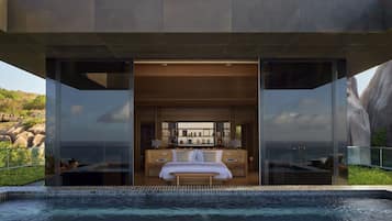 Relax in a spacious room with a central seating area, balcony, and comfortable bed.