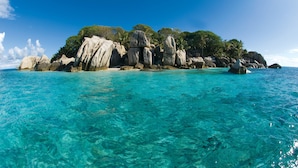 Vista despejada de una isla rocosa con aguas turquesas y un cielo claro.