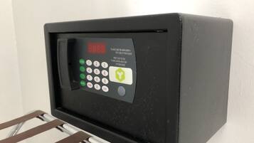 A black electronic keypad with a digital display, a green lock button, and a metal rack below it.