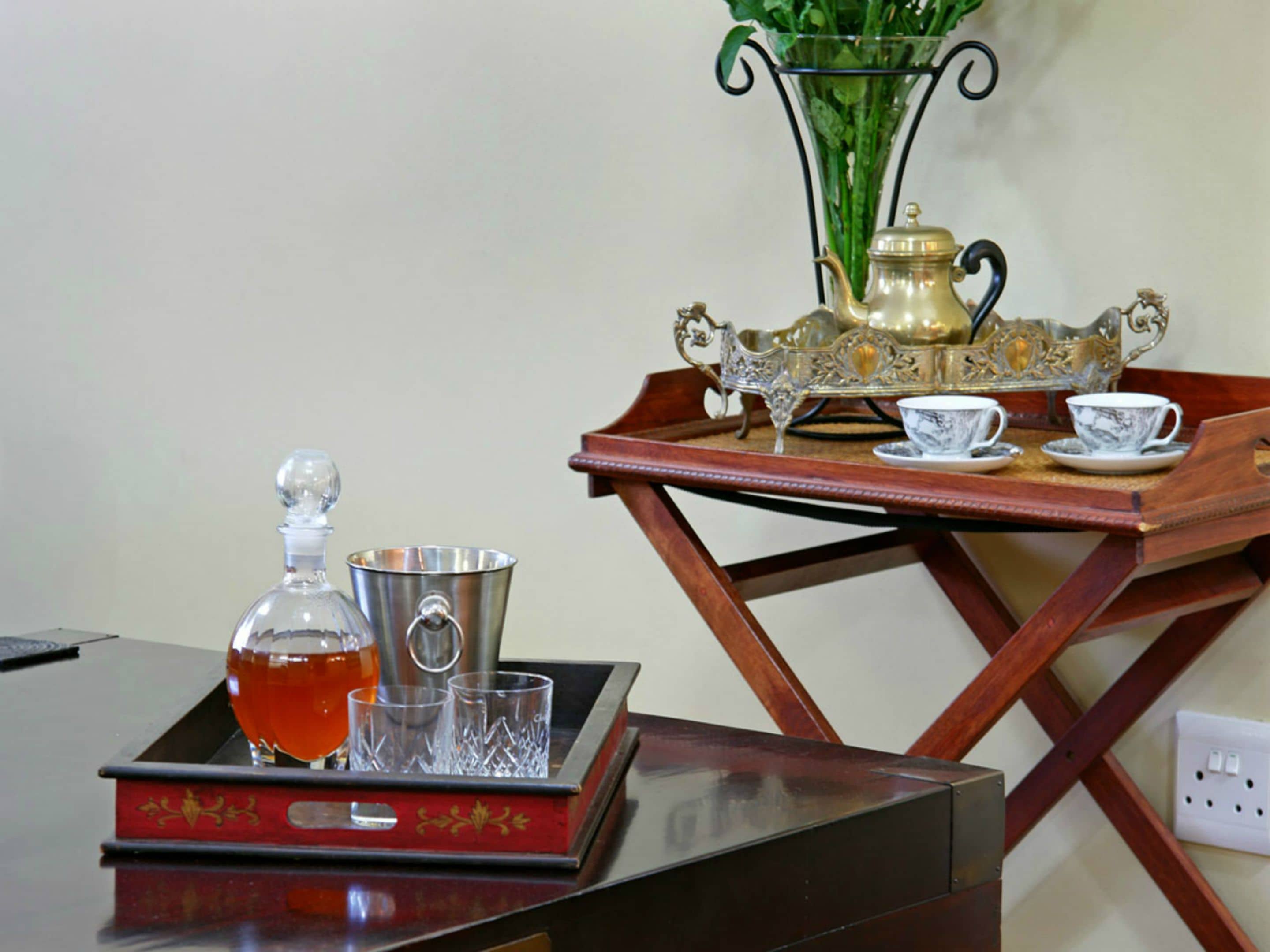 A tray with a decanter, glasses, and a pitcher on a wooden table.