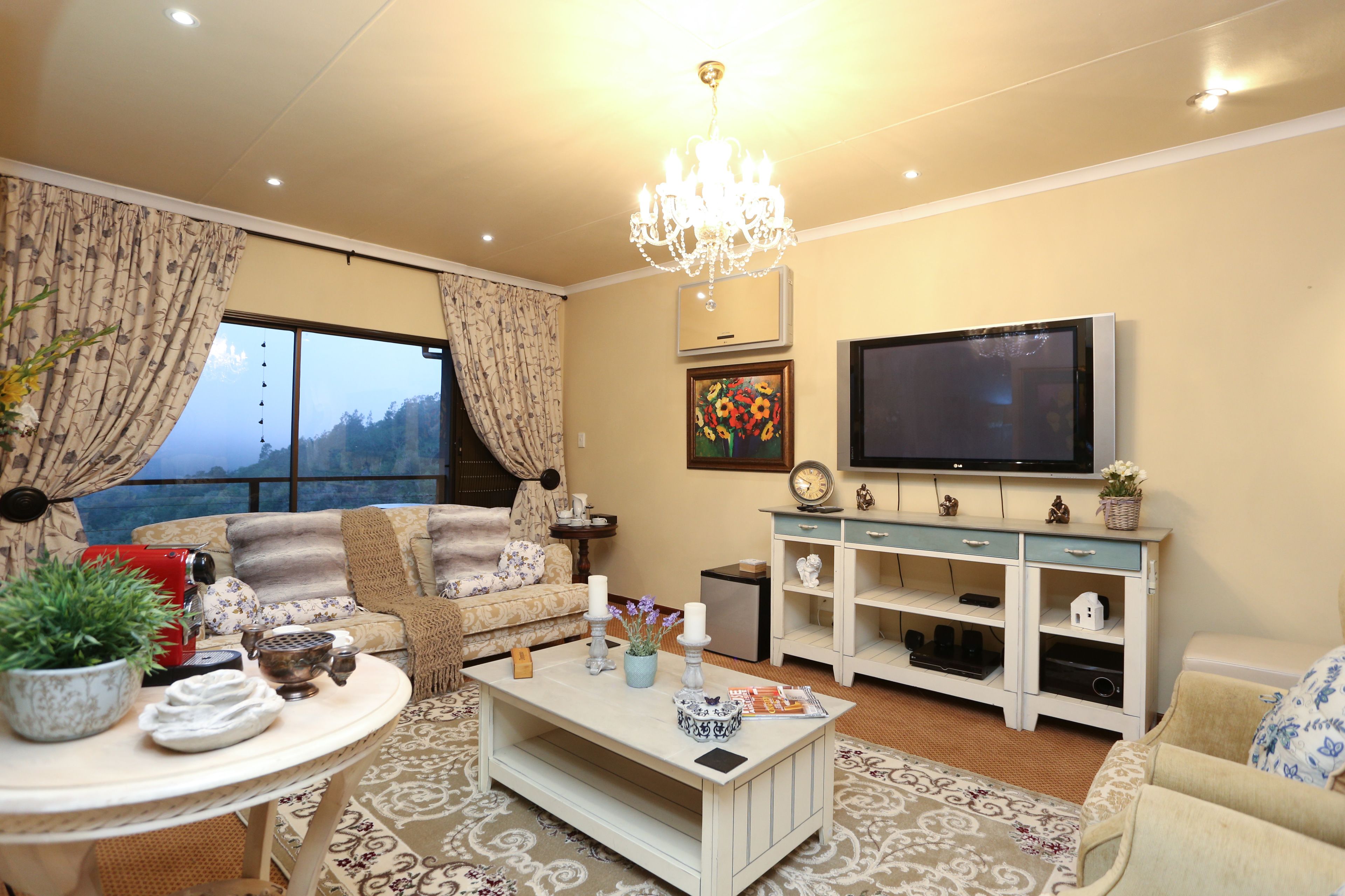 A living room with a sofa, coffee table, TV, and decorative items.