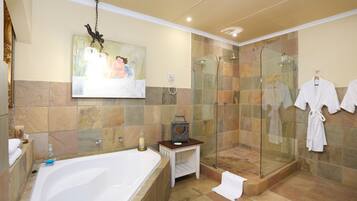 A modern bathroom with a large bathtub, a glass-enclosed shower, and a painting on the wall.