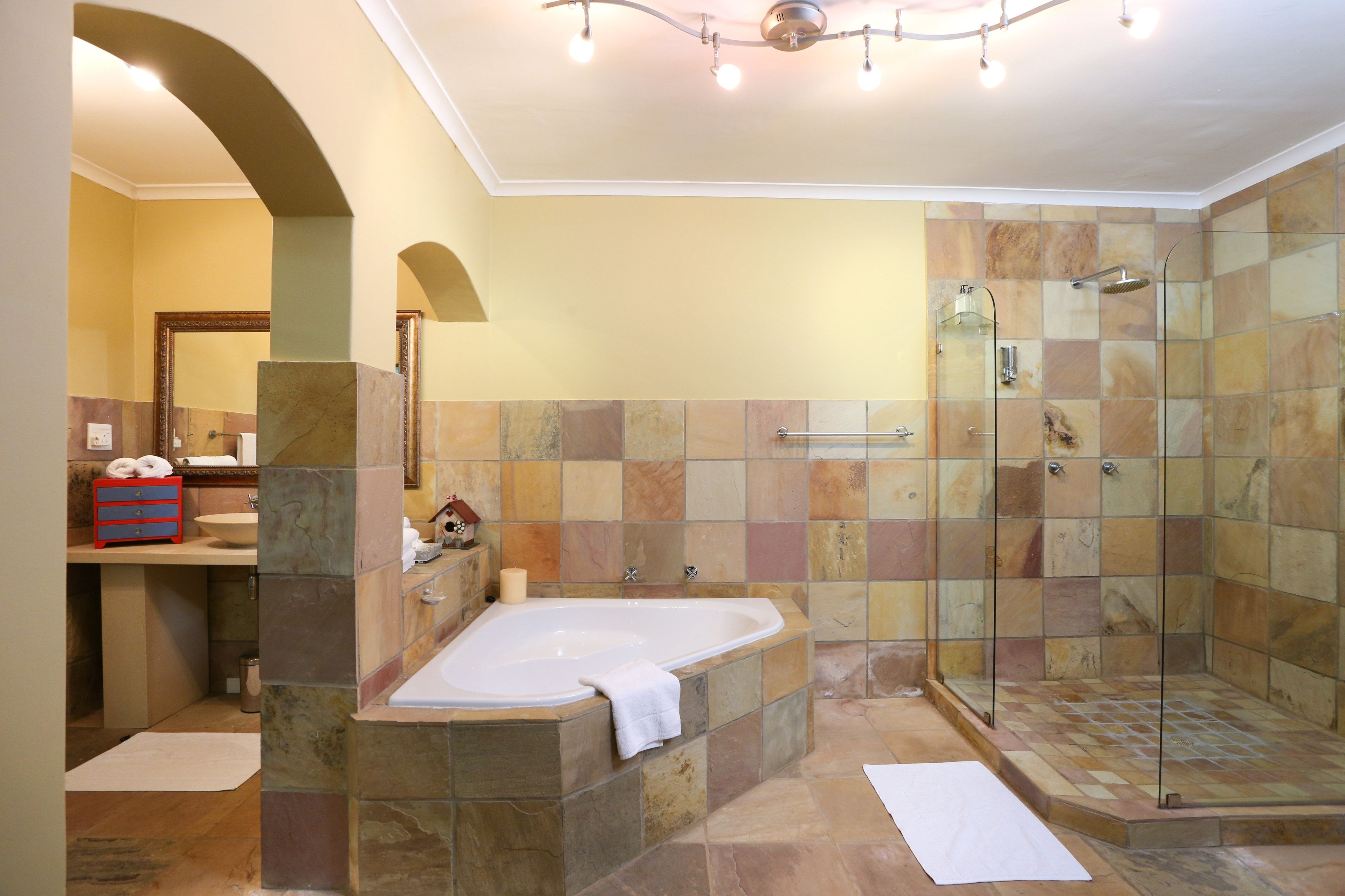 A bathroom with a bathtub, shower, and a vanity with a sink.